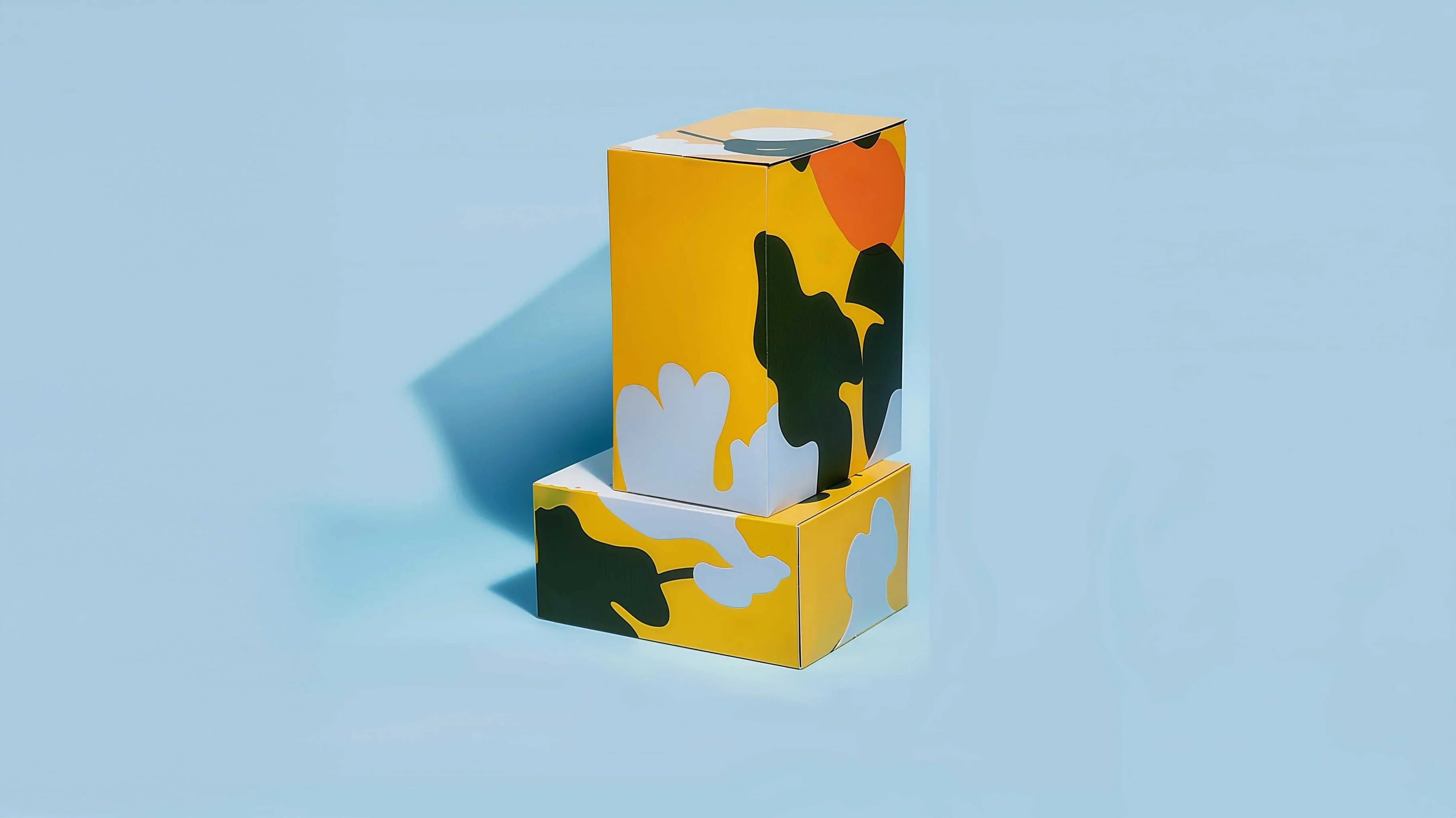 Stacked colorful cardboard boxes with abstract nature design on a light blue background